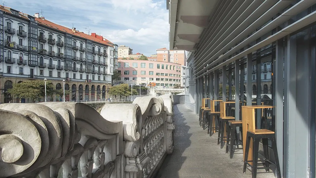 La animada terraza del Mercado de la Ribera, ofreciendo gastronomía y vistas a la ría.